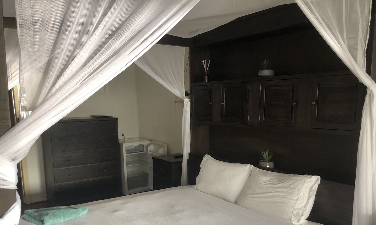 Proserpine Apartment | Clean tidy hotel room with a shared kitchen and shower area
