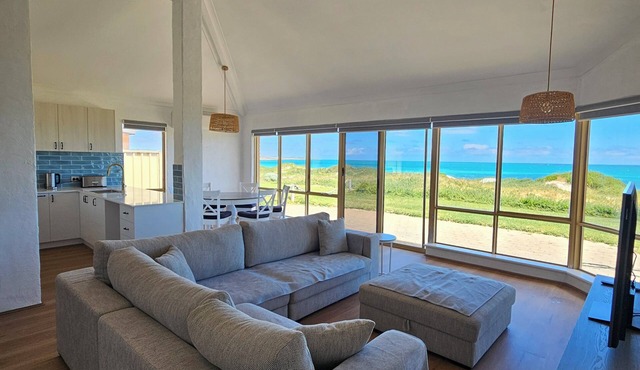Beachfront retreat with breathtaking views steps from the shore.