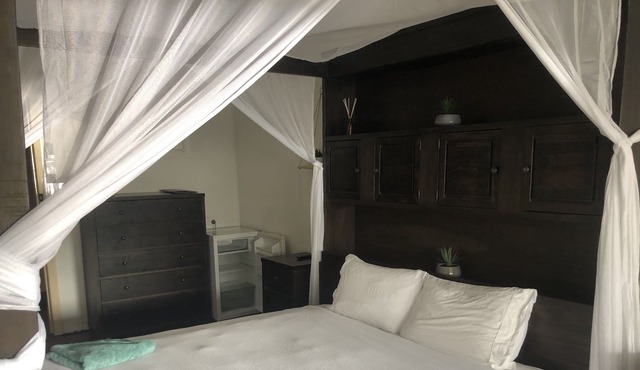 Clean tidy hotel room with a shared kitchen and shower area