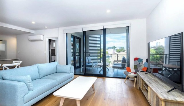 Rooftop Sky Lounge has a daybed, tables and stools, a lounge area with a big screen TV and a grassed